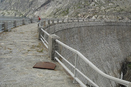 La Diga di Val Soera; in alto a destra, addossato al versante, il Rfiugio Pocchiola Meneghello (Foto P. Piatti, P. Quagliolo)