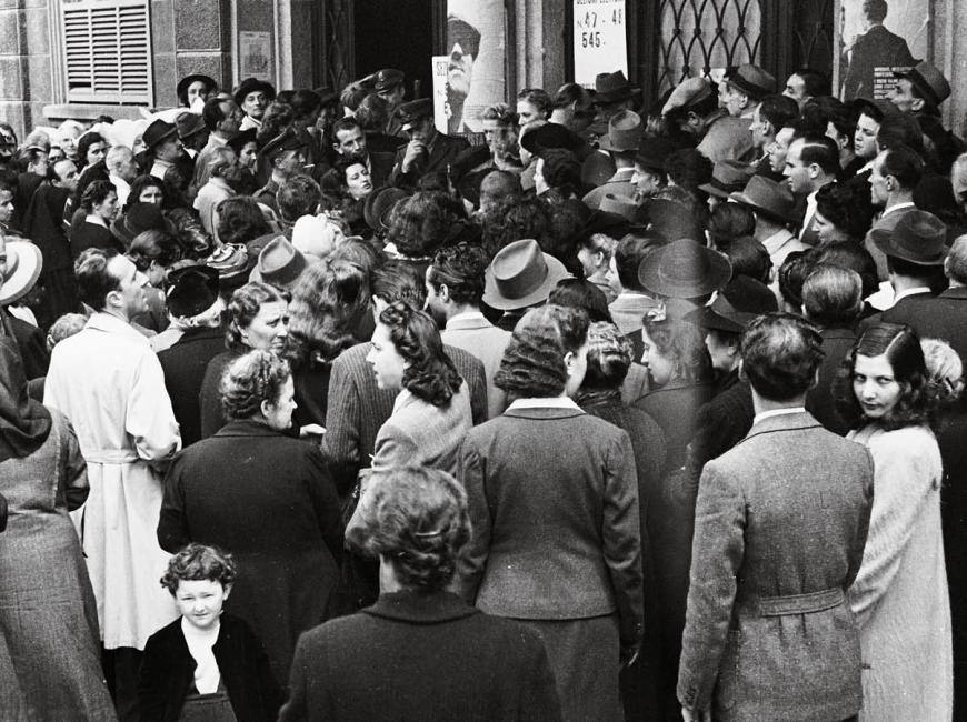 Immagine storica: folla di uomini e donne all'ingresso dei seggi elettorali del 2 giugno 1946
