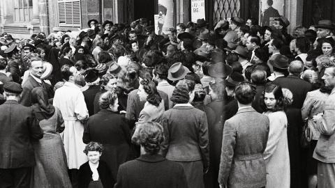 Immagine storica: folla di uomini e donne all'ingresso dei seggi elettorali del 2 giugno 1946